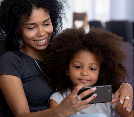 a mother and daughter checking a mobile device